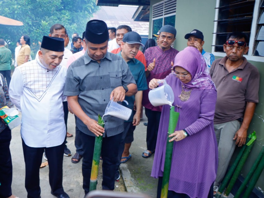 Bupati Kampar Ahmad Yuzar beserta Wakil Bupati Kampar  mengisi lomang saat pembukaan  Festival Lomang Ayo Onam I 2025 di Dusun Kampung Godang, Desa Pulau Lawas.