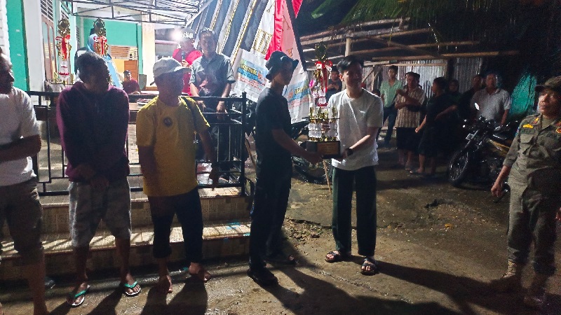 Ketua Komisi III DPRD Kuansing, Maulana Imam Saleh menyerahkan piala bergilir pada perwakilan Jalur Panglimo Hitam Bintang Nagori yang keluar sebagai juara I pada pacu Jalur ajang silaturahmi Inuman,