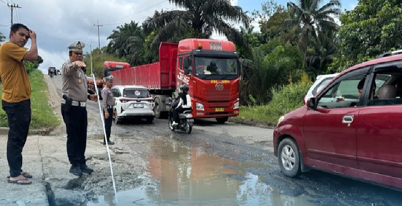 Kasatlantas Polres Inhu AKP Eri Asman SH saat meninjau dan mengatur lalulintas di Jalan Lintas Timur di Kecamatan Lirik yang mengalami rusak, Ahad (6/4/2015)