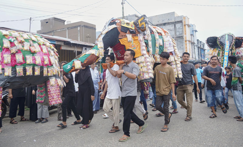 Masyarakat Basrah, Kecamatan Kuantan Hilir menjunjung sisampek dalam perayaan hari Rayo Onom, Senin (7/4/2025) menuju rumah godang suku masing-masing.