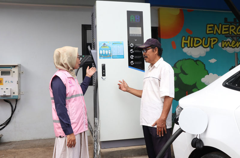 Estuning Rahayu (kiri), Srikandi PLN ketika melayani pelanggan yang  hendak mengisi daya kendaraan listrik pada periode arus balik mudik Idulfitri 1446 H.