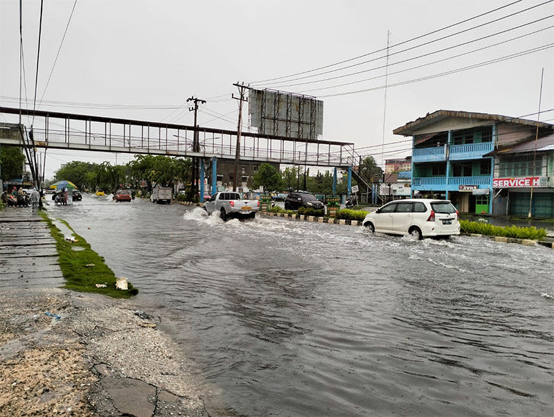 Sejumlah kendaraan roda empat, Jumat (11/4/2025) menerobos banjir dari guyuran hujan yang merendami Jalan Sultan Syarif Kasim Dumai.