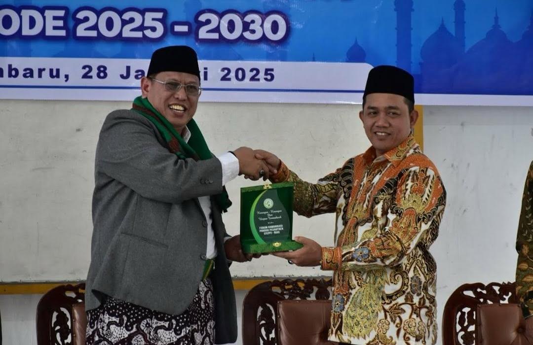Ketua DPRD Kota Pekanbaru Muhammad Isa Lahamid (kanan) menerima cendramata dari Ketua FKPP Kyai Muhammad Mursyid.
