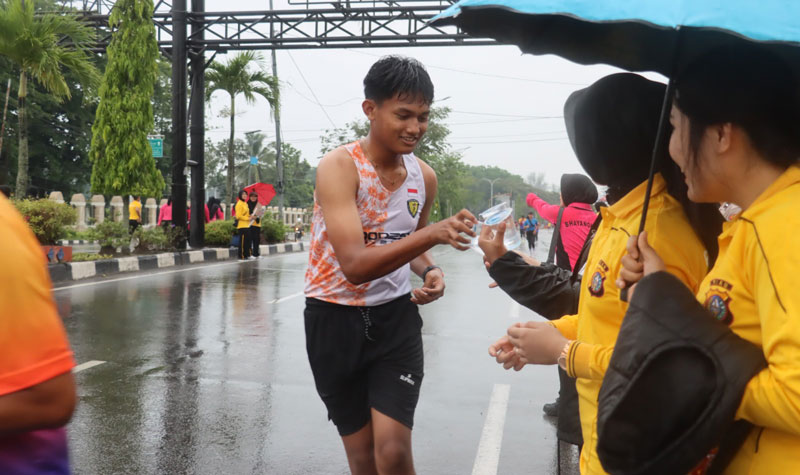 Seorang peserta Karhutla Fun Run 2025 Dumai  mengambil air mineral yang diberikan panitia, Ahad (13/4/2025).
