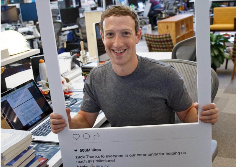 CEO Meta, Mark Zuckerberg, tersenyum sambil memegang model tampilan depan Instagram saat mengambil alih media sosial tersebut, beberapa waktu lalu.