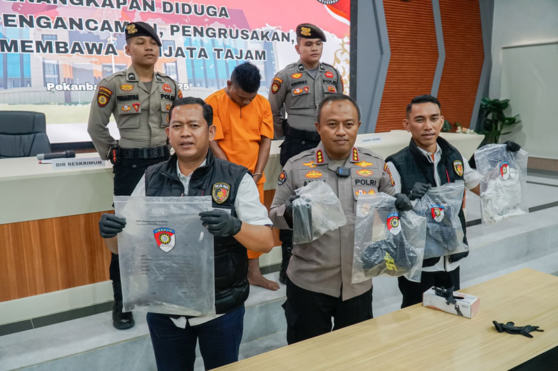 Kabid Humas Polda Riau Kombes Pol Anom Karibianto, Dirkrimum Polda Riau Kombes Pol Asep Darmawan (kiri)  memperlihatkan  pelaku penusukan mobil dan barang bukti pisau saat ekspose di Mapolda Riau.