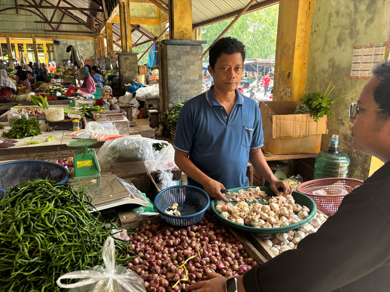 Pedagang Pasar Raya Belantik Siak Asmeldi menunggu pembeli, Selasa (15/4/2025).