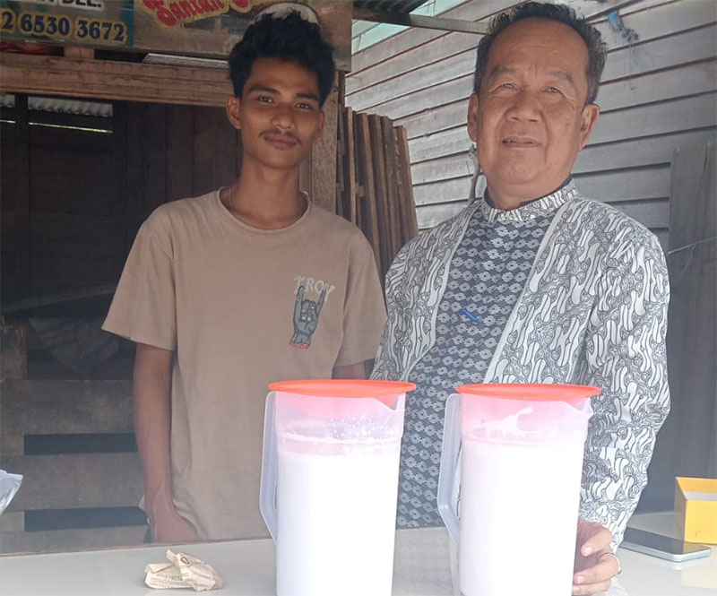 Kabid Perdagangan Dinas Kopdagrin Kuansing, Yean Asnudi bersama penjual santan kelapa di Teluk Kuantan, Kamis (17/4/2025).