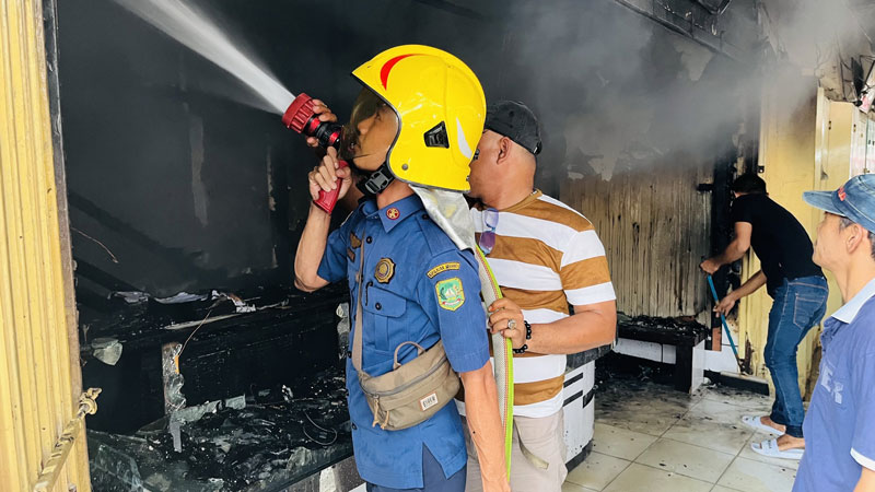 Petugas sedang memadamkan api yang membakar satu unit toko emas di Pasar Sandang Pangan, Selatpanjang, Kepulauan Meranti, Rabu (16/4/2025).