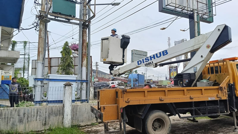 Petugas  dengan mobil operasional Dinas Perhubungan Kabupaten Inhu melakukan perbaikan lampu penerangan jalan umum di Kelurahan Pematang Reba, belum lama ini.
