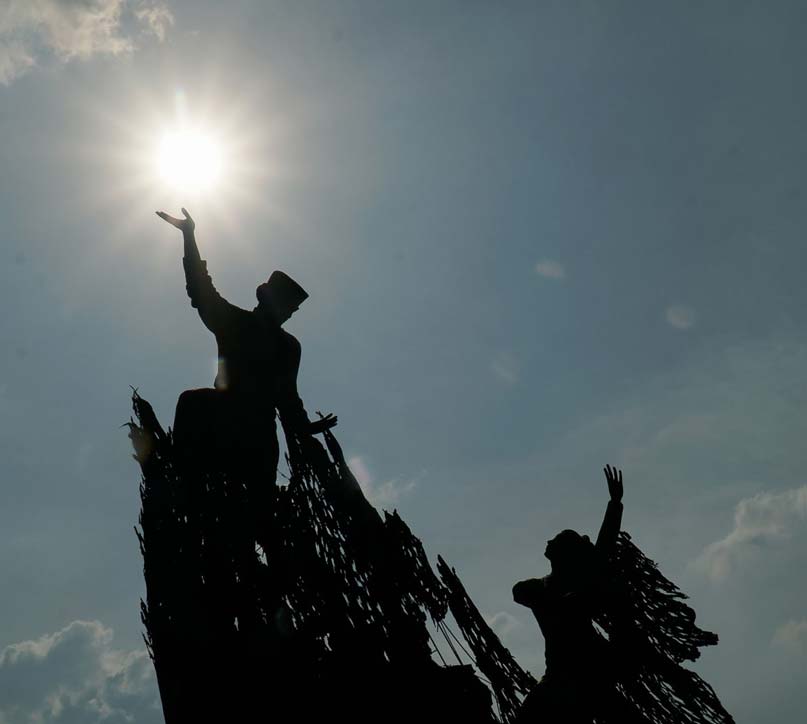 Tugu Zapin di Jalan Jenderal Sudirman Pekanbaru dengan latar belakang cahaya matahari yang terik.