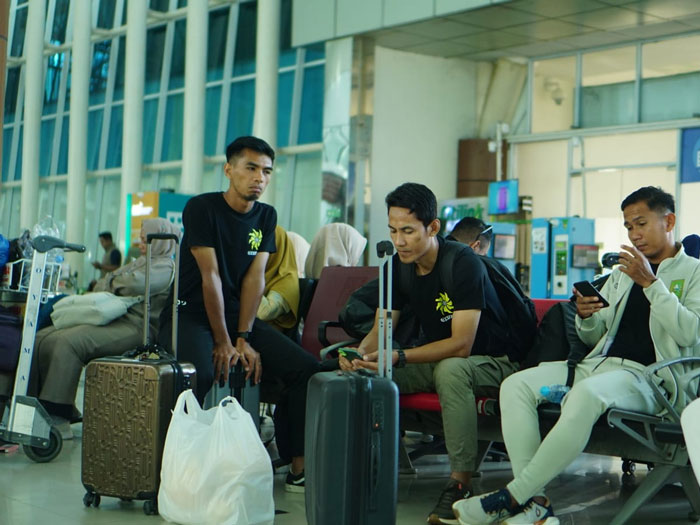 Pelatih Pekanbaru FC Ambrizal (2 kiri) dan Asisten Syahrian Gunanta (tiga kiri), pemain senior Suhendra Eka Saputra (kiri) menunggu keberangkatan pesawat di Bandara SSK II Pekanbaru, Ahad (20/4/2025)