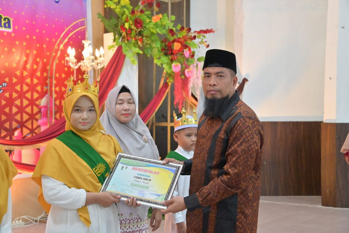 Asisten 1 Setdakab Bengkalis Andris Wasono menyerahkan piagam kepada siswa SDS Aisyiyah di Gedung Cik Puan Bengkalis, Sabtu (19/4/2025).