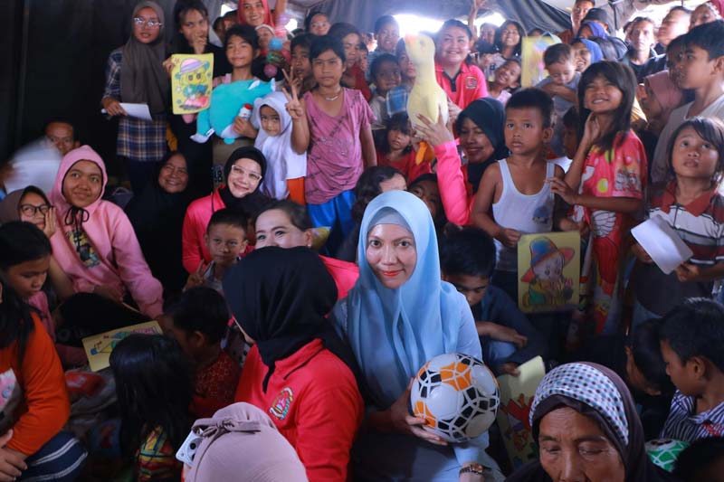 Ketua Tim Penggerak PKK Pekanbaru Sulastri bersama anak-anak warga Rumbai usai memberikan bantuan di tenda pengungsian saat banjir Maret 2025 lalu.