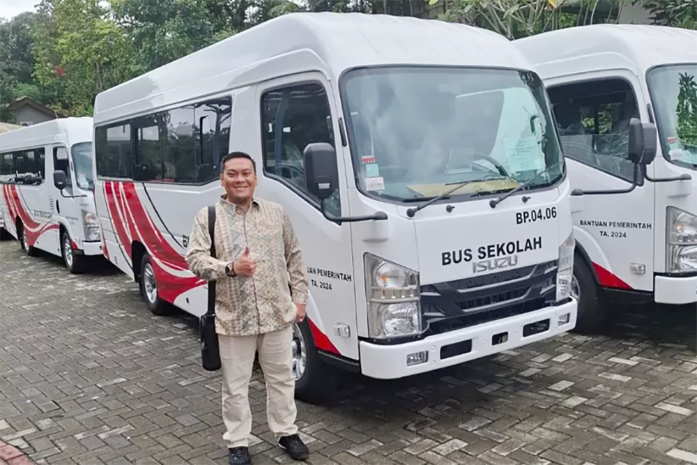 Kasi Angkutan Dishub Siak Janu Wira berfoto di depan bus pemberian Kemenhub, belum lama ini.