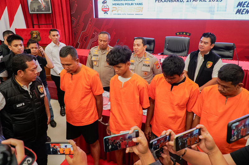 Dirkrimum Polda Riau Kombes Pol Asep Darmawan (kiri) berdialog dengan tersangka pengeroyokan debt collector saat ekspose di Mapolda Riau, Pekanbaru, Senin (21/4/2025).