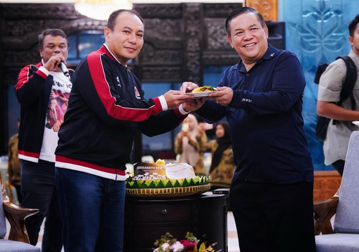 Ketua FPTI Riau SF Hariyanto menyerahkan potongan tumpeng kepada Wakil Ketua Umum FPTI Irjen Pol Herry Heryawan saat syukuran HUT FPTI, Senin (21/4/2025) malam.