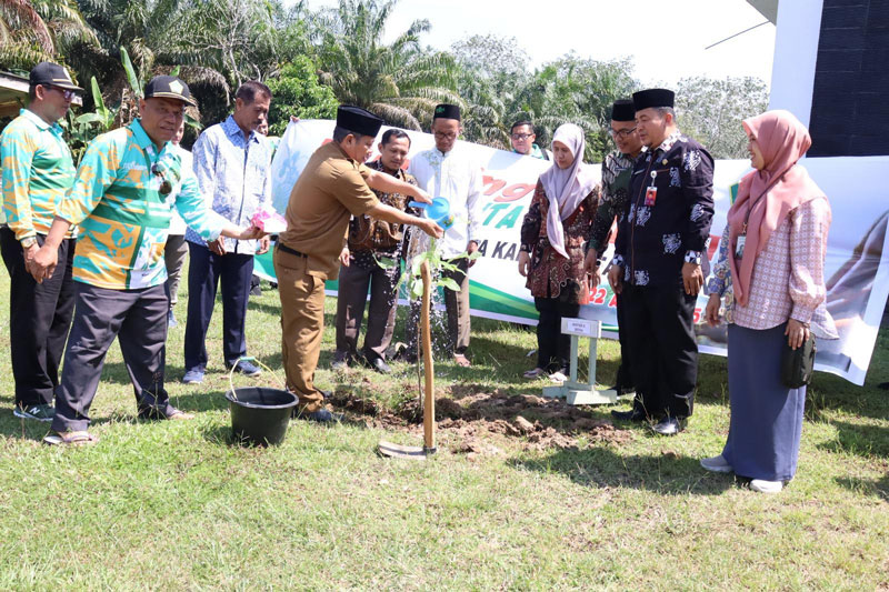 Asisten II Setdakab Kuansing Ir H Maisir disaksikan Plh Kemenag Kuansing Dr H Bakhtiar Saleh (dua kanan) menyiram bibit matoa yang baru ditanam dalam peringatan Hari Bumi di kantor Kemenag Kuansing.