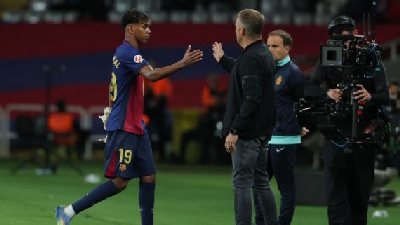 Manajer Barcelona Hansi Flick memberi selamat kepada Lamine Yamal saat ia meninggalkan lapangan selama pertandingan melawan Real Mallorca.