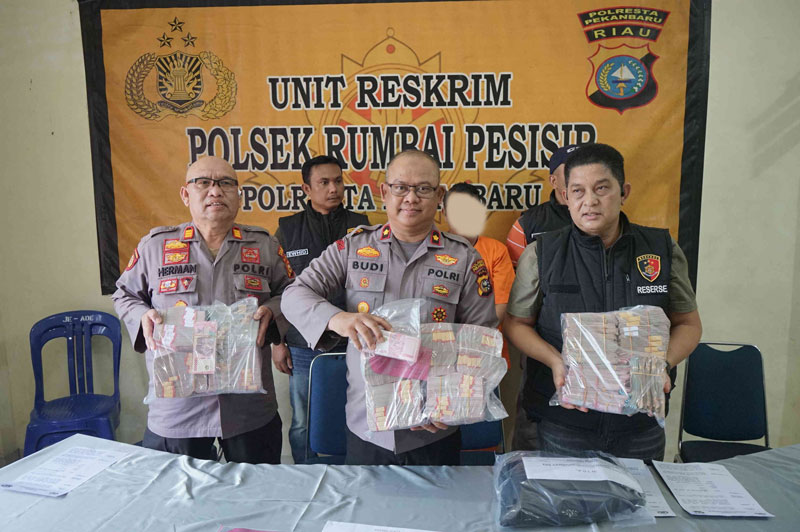 Kapolsek Rumbai Pesisir Kompol Budi Pramana (tengah) didampingi Wakapolsek AKP Herman (kiri), Kanit Reskrim Iptu Marcopolo (kanan) memperlihatkan barang bukti berupa uang tunai saat ekspose.