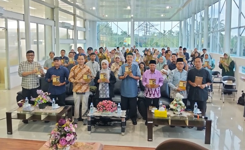 Para peserta Bincang Buku Kampung Nyamuk: Percikan Sejarah Rakyat Pekanbaru, menunjukkan buku yang didiskusikan di Perpustakaan Tennas Effendy, Sabtu (26/4/2025).