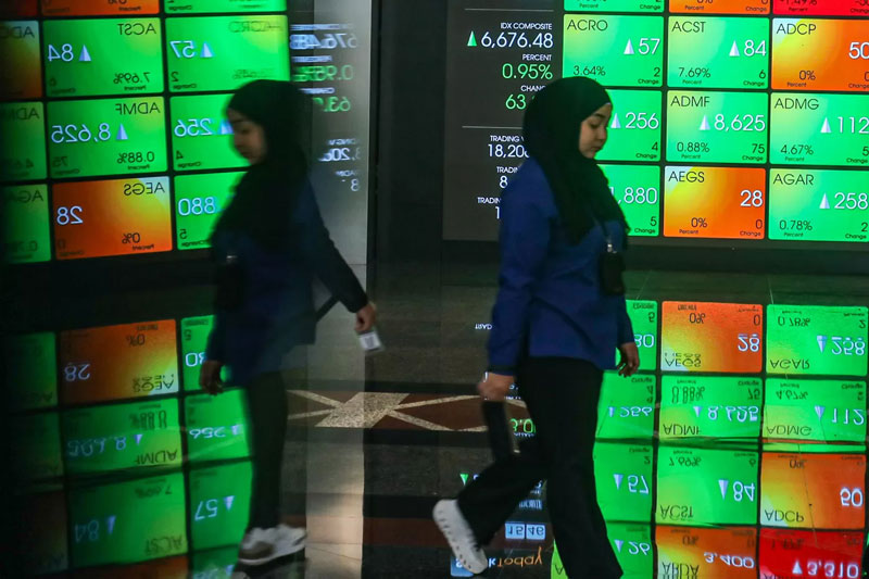Karyawan berada di dekat layar pergerakan Indeks Harga Saham Gabungan (IHSG) di Gedung Bursa Efek Indonesia, Jakarta, Jumat (25/4/2025).