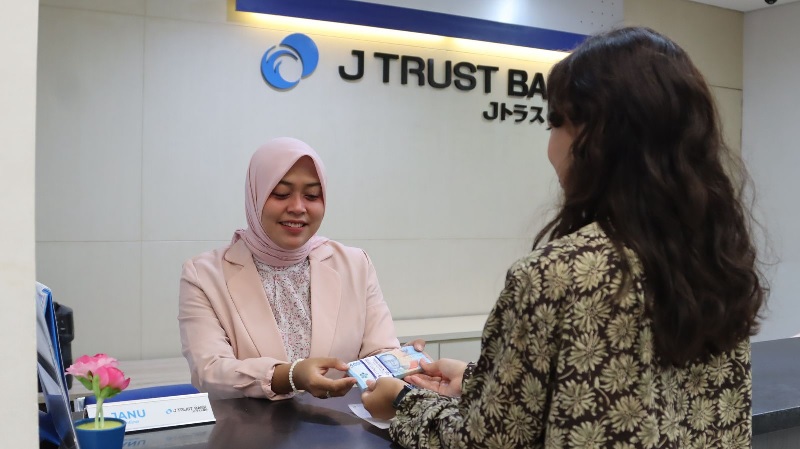Pegawai J-trust Bank melayani nasabah yang melakukan transaksi, Senin (28/4/2025).