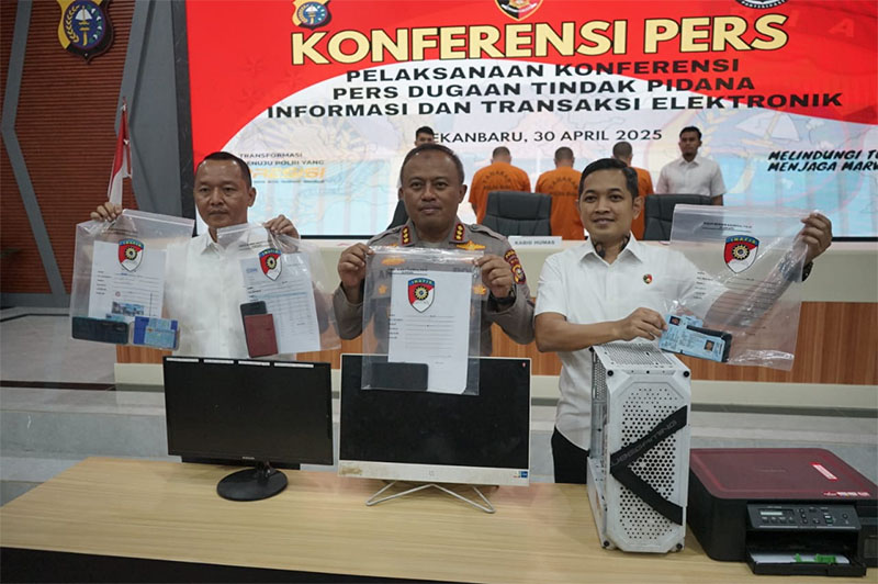Dir Reskrimsus Polda Riau Kombes Ade Kuncoro Ridwan dan Kabid Humas Kombes Anom Karabianto memperlihatkan barang bukti saat ekspos kasus tindak pidana ITE di Aula 91 Media Center Mapolda Riau