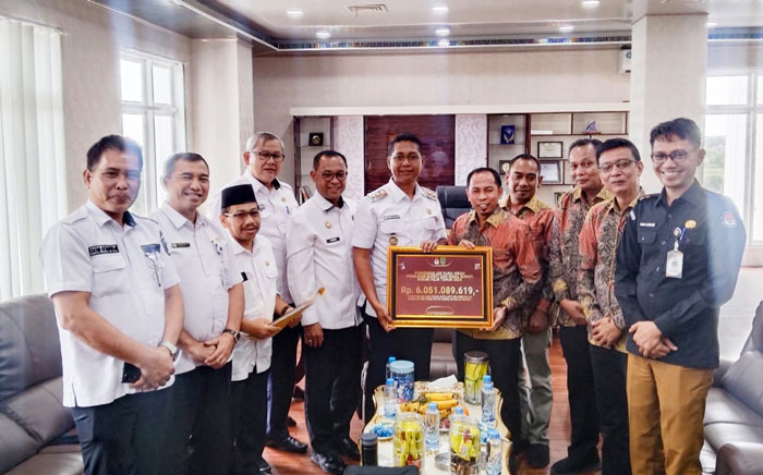 Ketua KPU Rohil Eka Murlan SE Sy didampingi para komisioner menyerahkan secara simbolis sisa dana hibah kepada pemda Rohil yang diterima Wabup Jhony Charles di Bagannsiapiapi, Rabu (30/4/2025).