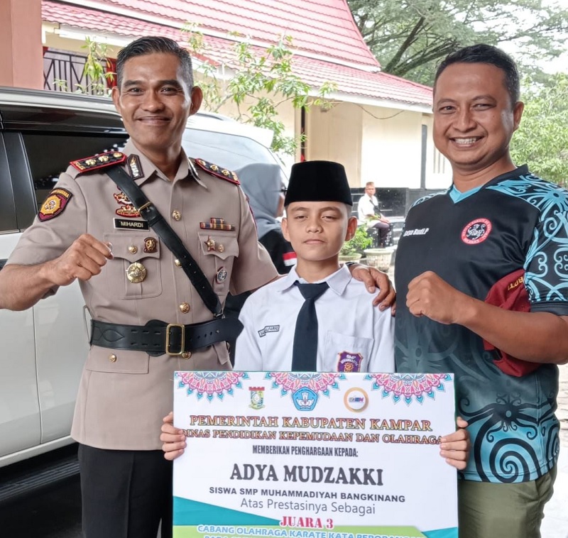 Saddam mewakili Adya Mudzakki didampingi Kapolres Kampar AKBP Mihardi Mirwan dan pelatih Satya Budhi Pratama usai menerima penghargaan sempena Hardiknas di Lapangan Pelajar Kota Bangkinang.