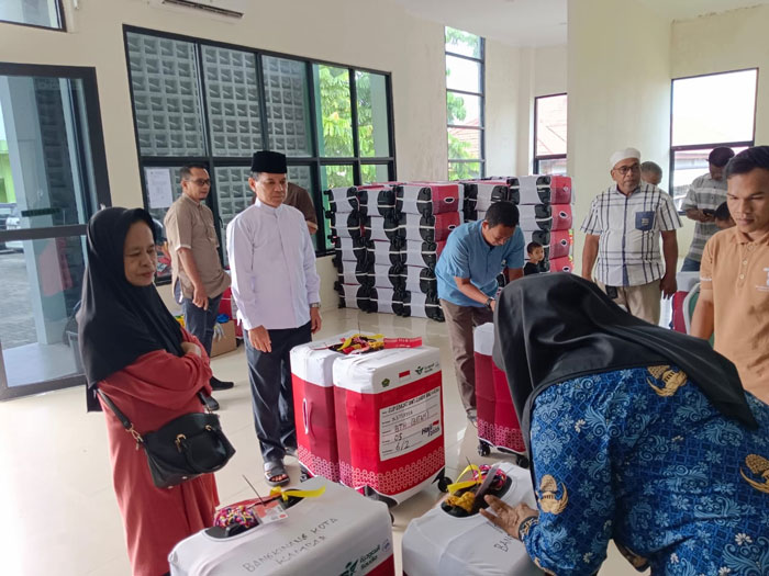 Kepala Subbag Tata Usaha Kantor Kemenag Kabupaten Kampar H Dirhamsyah (baju koko putih) saat meninjau kesiapan koper JCH di gedung PLHUT Kantor Kemenag Kampar, Bangkinang, Jumat (2/5/2025).