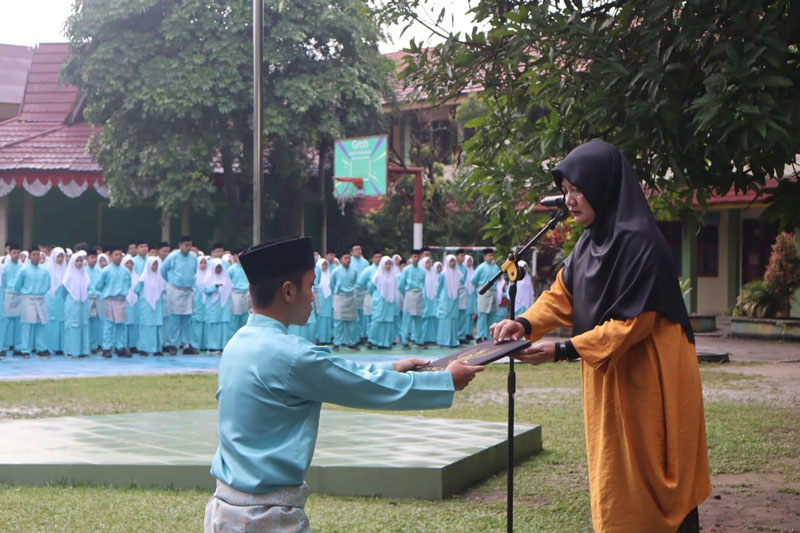 Pembina upacara peringatan Hari Pendidikan Nasional Titin Indayani MPd menyerahkan teks pidato Menteri Dikdasmen RI kepada ajudan usai dibaca, Jumat (2/5/2025).