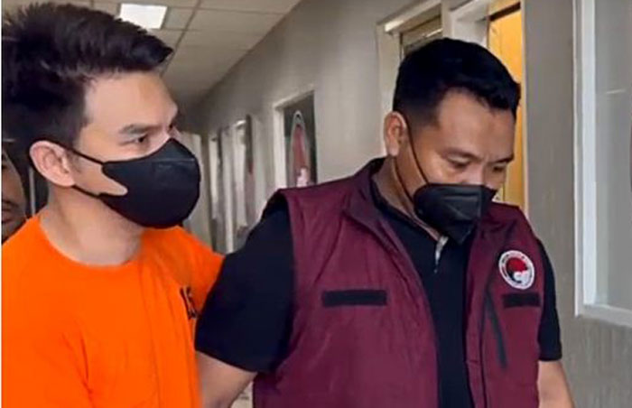 Jonathan Frizzy memakai baju oranye resmi ditetapkan sebagai tersangka vape obat keras, diduga melanggar UU Nomor 17 Tahun 2023 Tentang Kesehatan.
