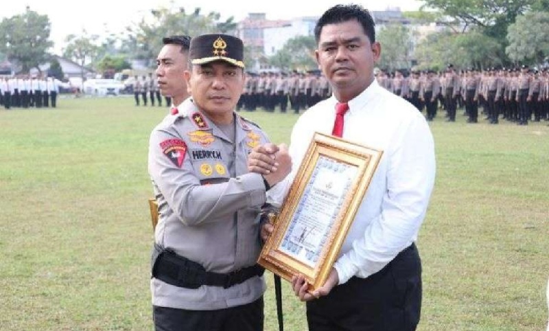 Kasat Reskrim Polresta Pekanbaru, Kompol Bery Juana Putra, SIK MH (kanan) saat menerima penghargaan dari Kapolda Riau Irjen Pol Dr Herry Heryawan, SIK MH MHum,di Halaman Apel Mapolda Riau.