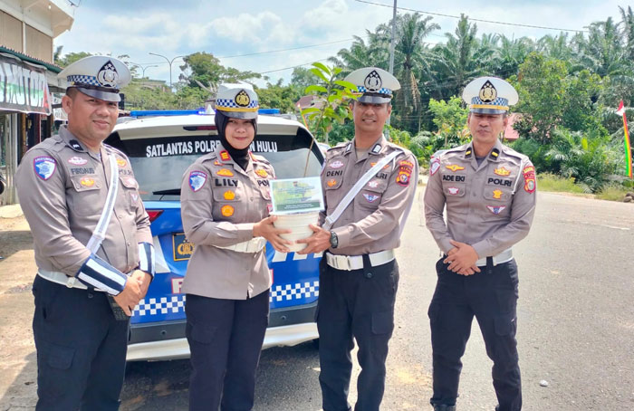 Kasat Lantas Polres Rohul AKP Lily Sulfiani SH MH memberikan kejutan kado berupa 1 batang bibit pohon sirsak kepada Anggota Bripka Deni Juliardi saat menjalankan tugas di lapangan, Kamis (8/5/2025).