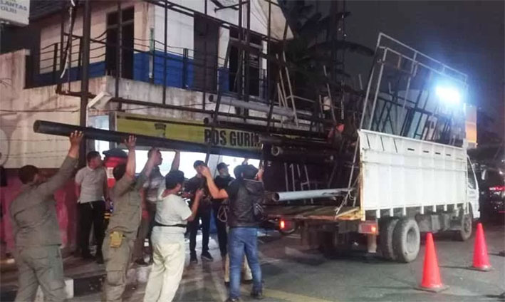 Tim gabungan Pemko Pekanbaru membongkar tiang reklame diduga ilegal yang berdiri di salah satu jalan di Kota Bertuah.