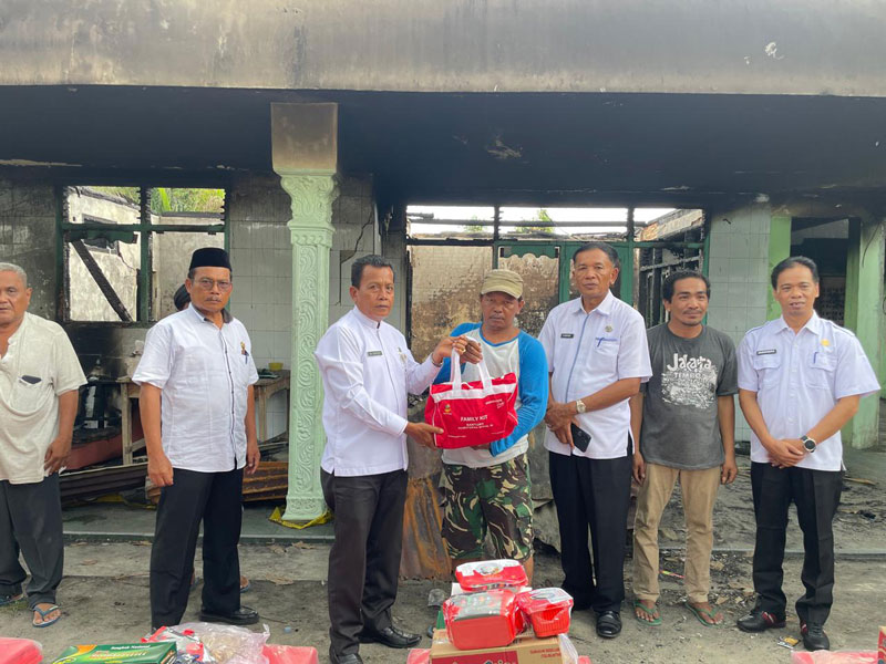 Kepala Dinas Sosial Pekanbaru Idrus (tiga kiri) serahkan bantuan kepada masyarakat korban musibah kebakaran di Kelurahan Tirta Siak.