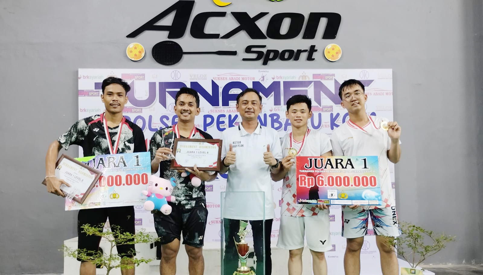 Juara 1 level B ganda putra, Rian AH dan Tomy (kiri) dan juara 1 Level C, pasangan ganda putra, Hans dan Willy (kanan) foto bersama Ketua Pelaksana Turnamen Badminton Kapolsek Pekanbaru Kota Simpatig Cup 2 2025 Kompol H Herman Pelani SH MH (tengah).
