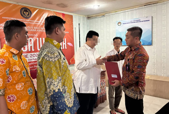 Kepala Seksi Bimbingan Narapidana dan Anak Didik Lapas Kelas IIA Pekanbaru Angki Setyo Andrianto (kanan), menyerahkan remisi Waisak secara simbolis kepada napi beragama Buddha, Senin (12/5/2025).
