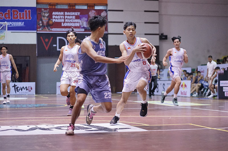 Pemain SMAN 2 Bandung Alaric Pramaldan (putih) berusaha melewati adangan pemain SMA Witama Pekanbaru saat pertandingan Turnamen Rajawali Cup III 2025 di GOR Tribuana Pekanbaru, Selasa (13/5/2025).