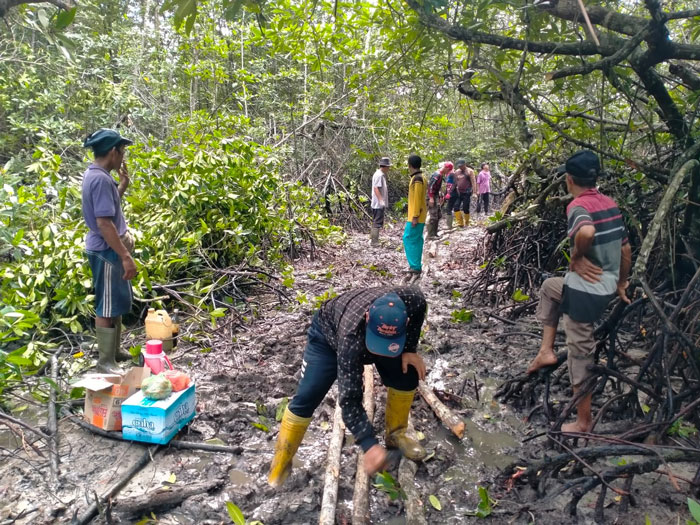 Masyarakat Desa Teluk Lancar membersihkan jalan setapak menuju ke laut yang selalu digunakan masyarakat untuk mencari kepah, Jumat (16/5/2025).