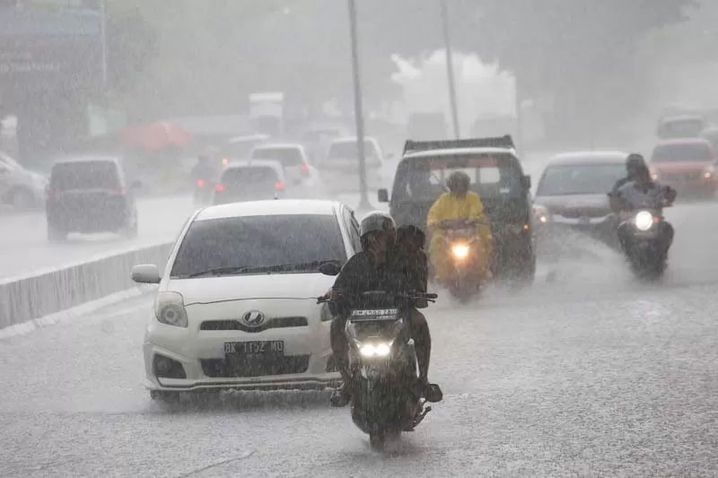 Pengendara menerobos hujan deras di kawasan Pasar Pagi Arengka, Pekanbaru, baru-baru ini.