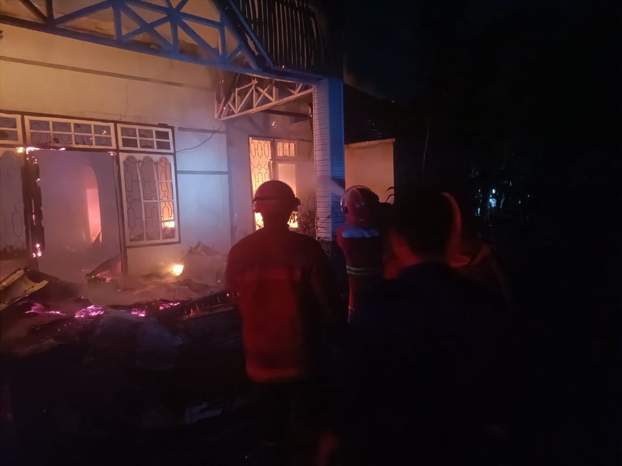 Personel Damkar Kabupaten Kampar memadamkan api yang membakar satu unit rumah di Jalan Ahmad Yani, Kelurahan Langgini, Kecamatan Bangkinang Kota, Kabupaten Kampar, Jumat (16/5/2025) malam.