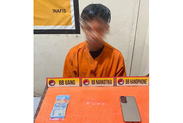 Tersangka pengedar narkoba inisial EY ketika diamanakan bersama barang bukti di Mapolres Inhil, Senin (19/5/2025).