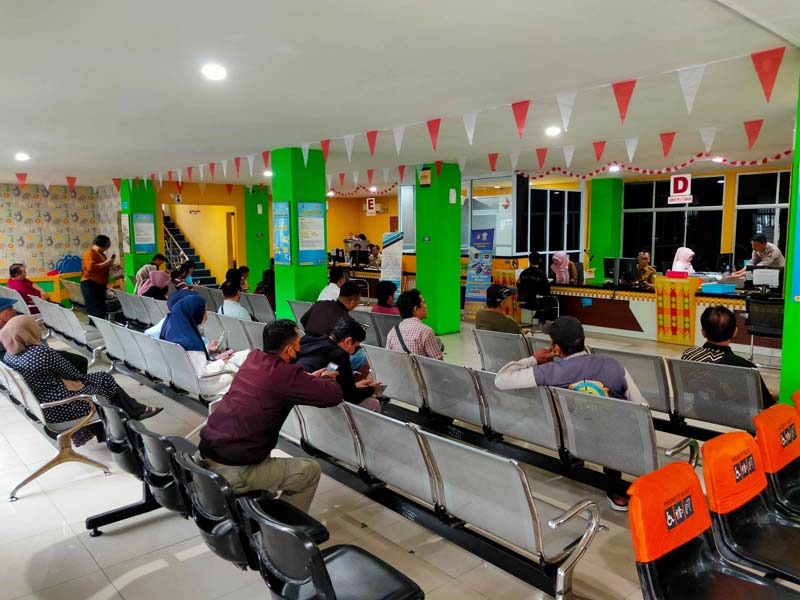 Warga Pekanbaru duduk di bangku menunggu giliran membayar pajak di Kantor UPT Samsat Jalan Gajah Mada Pekanbaru, Senin (19/5/2025).