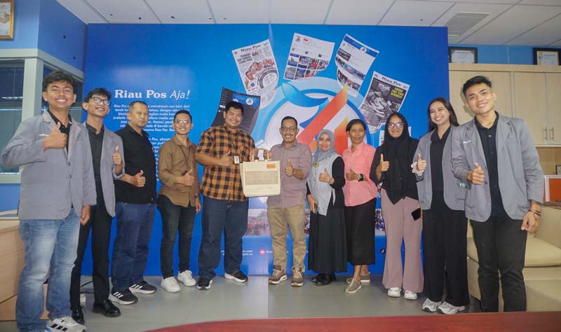 Direktur Riau Pos Asmawi Ibrahim (enam kanan) menerima cendera mata yang diserahkan  Ketua Program Studi PR dan Komunikasi Digital  PCR Anggi Trisnadolli (lima kiri)
