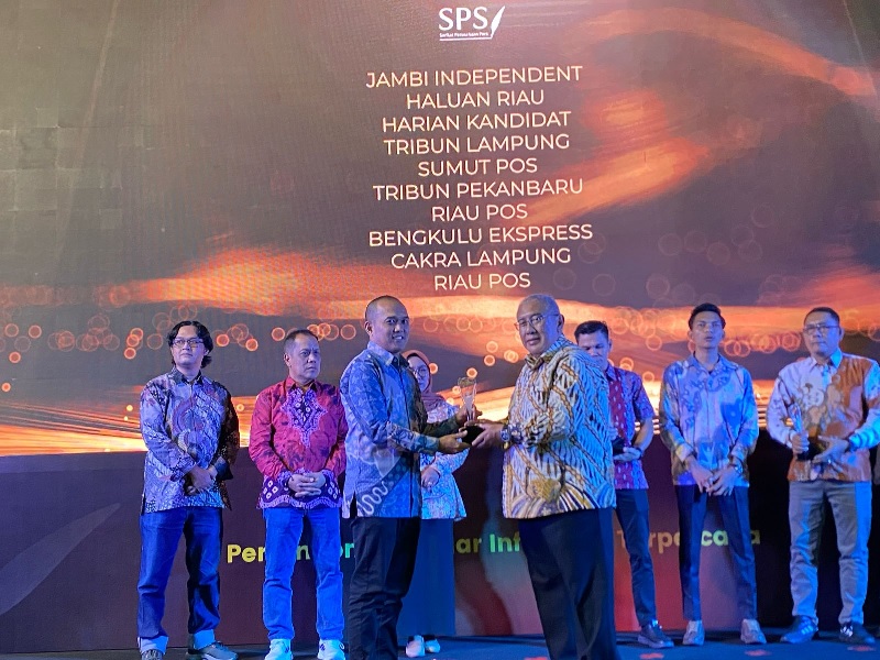 Ketua Umum SPS Januar P Ruswita menyerahkan dua trofi Gold Winner The Best of Sumatera Newspaper Kategori Indonesia Print Media Award 2025 kepada Manager Perwakilan Riau Pos Jakarta, Ari Iswandi.
