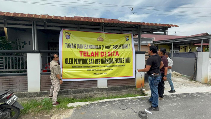 Tim Polres Inhu saat memasang spanduk penyitaan aset milik Mak Gadi, Rabu (22/5/2025).