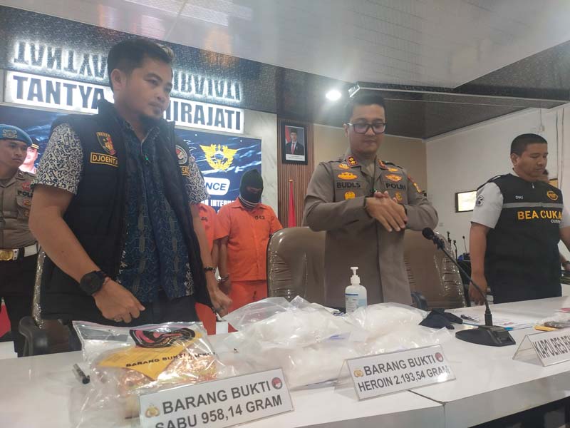 Kapolres Bengkalis AKBP Budi Setiawan (tengah) memperlihatkan barang bukti heroin dan sabu saat ekspose di Aula Kantor Polres Bengkalis, Jumat (23/5/2025).
