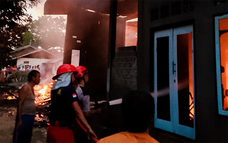 Petugas pemadam kebakaran Pemkab Kuansing berupaya memadamkan api yang membakar rumah milik warga Desa Koto Sentajo, Selasa (27/5/2025).
